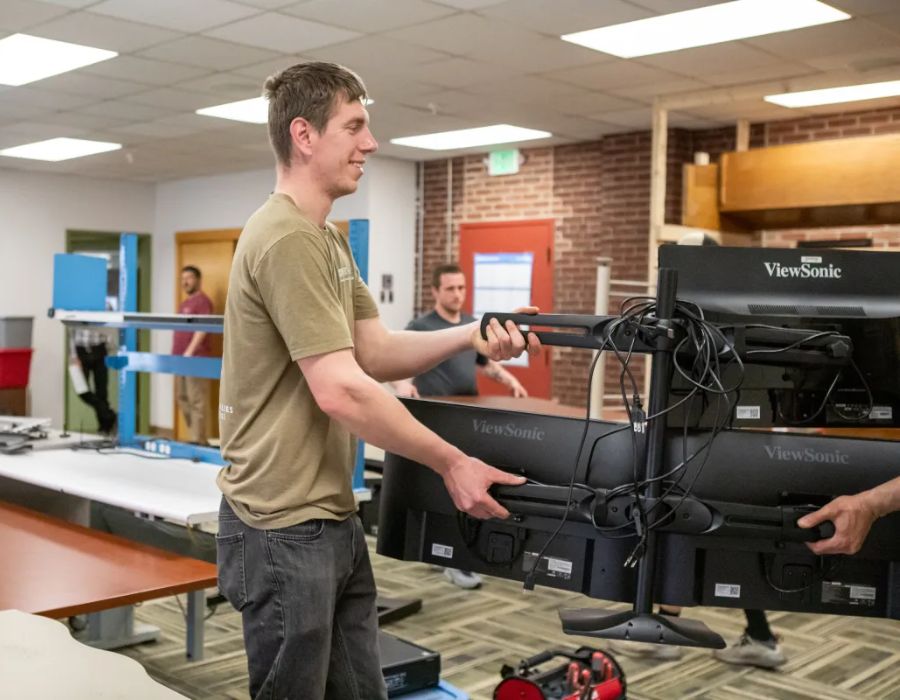Man carrying multiple computer monitors
